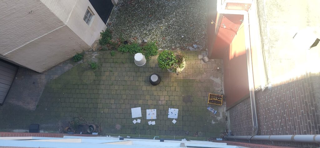 De oude situatie: veel bestrating en een gevaarlijk hoogteverschil met de tuin van de buren.